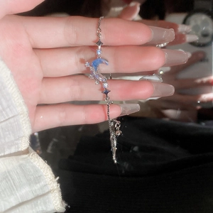 Dettaglio macro del bracciale con luna d'argento, pietre blu e ciondoli a stella
