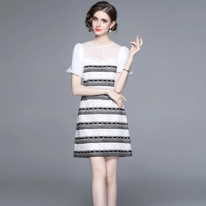Elegant black and white lace dress with mesh sleeves and a cinched waist design