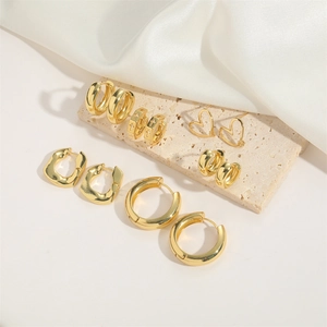 Set of 6 gold hoop earrings with heart and cross designs on textured stone base