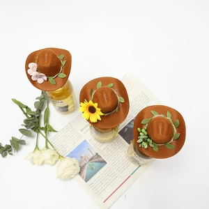 Miniature brown felt cowboy hats with floral decorations for party bottle toppers