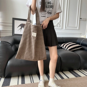 Detailed view of the brown plaid texture and woven fabric on the large tote bag