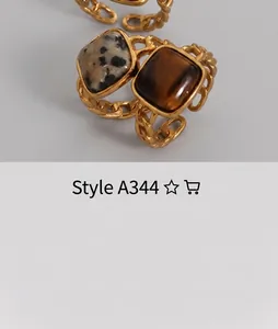 Detail of vintage gold Cuban chain rings featuring square Dalmatian and tiger eye stones