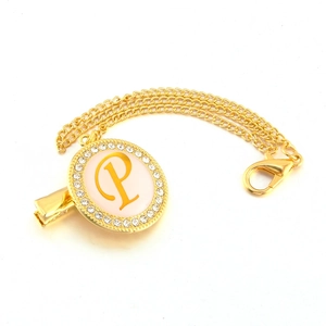 Macro view of gold pacifier clip with letter P and sparkling rhinestone details