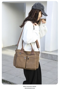Braune Canvas-Umhängetasche mit verstellbarem Riemen am Modell im Streetstyle-Look gezeigt