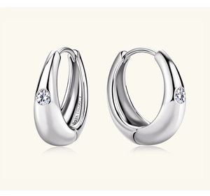 Close-up of S925 sterling silver earrings showing the 0.06CT hallmark and round diamond