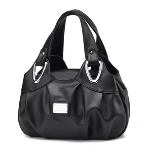 Detail of black faux leather handbag featuring ruched design and silver metal hardware