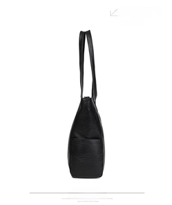 Detailed side view of black pebbled leather tote bag showing width and texture