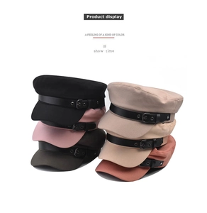 Detailed stack of multi-colored cotton baker boy caps featuring black leather buckle straps