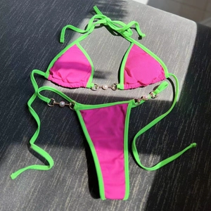 Detail of ribbed bikini with pearl and metal chain links in hot pink and lime green