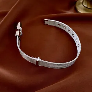Minimalist silver mesh star bracelet with adjustable pin buckle on brown silk fabric