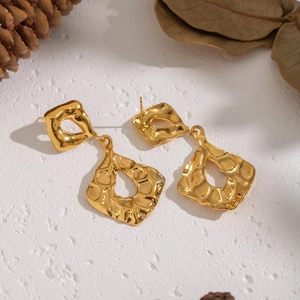 Minimalist golden stainless steel geometric earrings with hammered texture on white surface