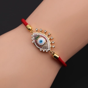 Detailed shot of an Evil Eye red cord bracelet with colorful rhinestones and gold accents