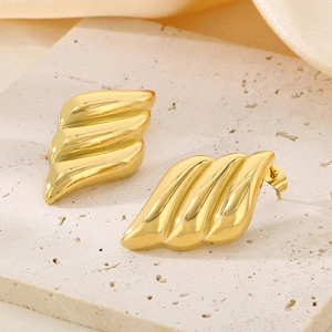 Elegant 18K gold plated wing earrings with textured wavy design on beige stone stand