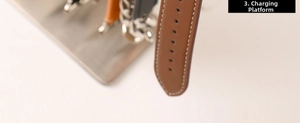Detalle de correa de reloj de cuero marrón con costuras blancas en soporte de carga inox