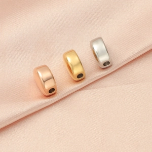 Detailed view of polished stainless steel spacer beads in gold, silver, and rose gold