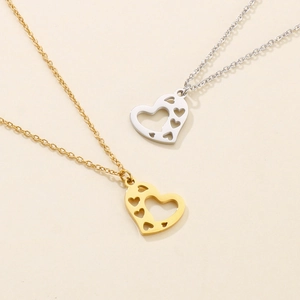 Detail of gold and silver hollow heart necklaces set in polished stainless steel