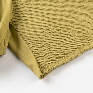 Close-up of olive green pleated elastic fabric texture on a slim-fit halter top