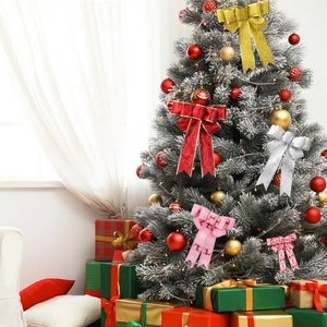 Festive Christmas tree bows in gold, red, and silver hanging on a decorated pine tree