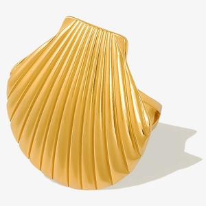 Macro shot of gold-plated seashell ring showing detailed textures and polished metal finish