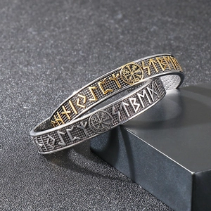 Detail of Viking compass and Odin runes engraved on textured stainless steel bangles