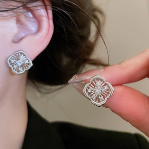 Detailansicht hohler Blumen-Ohrstecker aus Silber mit Zirkon und Perlen am Model getragen