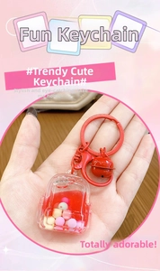 Close-up of a red mini backpack keychain featuring colorful liquid sand and a small bell