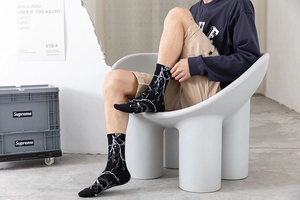Gros plan de chaussettes noires en coton à motif éclair blanc et étiquette ZHI
