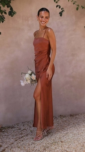 Close-up of caramel satin slip dress featuring elegant side slit and thin shoulder straps