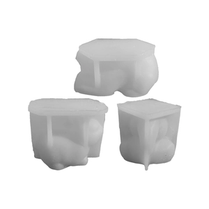 Three rabbit shaped silicone molds for DIY candle making and flower pots on white background
