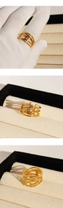 Detailed close-up of layered gold zircon rings with irregular lines on elegant white glove