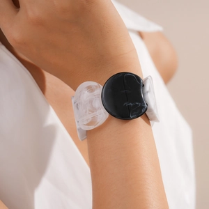 Close-up of marbled acrylic geometric bracelet on wrist with black and white resin finish