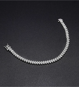 Close-up of sparkling silver moissanite tennis bracelet with secure buckle on black background