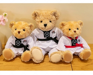 Gros plan de trois ours en peluche Taekwondo en doboks blancs avec ceintures noires et rouges