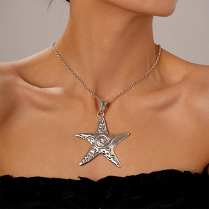 Close-up of a large vintage silver starfish pendant necklace with hammered texture details
