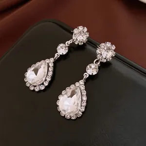 Elegant silver-tone water drop crystal earrings with floral cluster design on black base