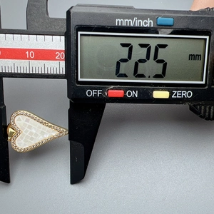 Digitaler Messschieber misst die 22,5 mm Breite des Herzanhängers aus Muschel