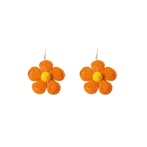 Detail of hand-woven raffia flower earrings in bright orange and yellow tones