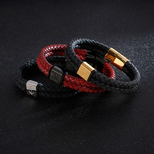 Detail of woven leather anchor bracelets with metallic magnetic clasps on dark background