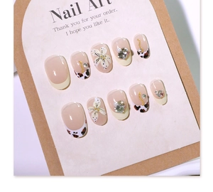 Detail of 3D flower press-on nails with leopard print, pearls and gold chain accents