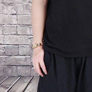 Close-up of golden skull head clasp on wide metal hip-hop style bracelet for men