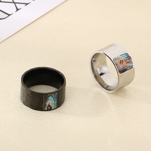 Detail of wide hammered stainless steel rings with colorful shell inlay in black and silver