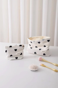 Detail of two-piece heart pattern cosmetic bags with textured white embossed fabric