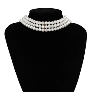 Close-up of triple-layer white pearl choker necklace with gold metal connector bar