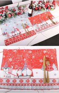 Detail of Christmas gnome table mat with red wine and festive tableware setup