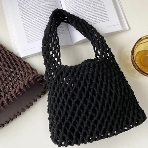 Minimalist black cotton rope woven tote bag shown from a top-down view with modern props