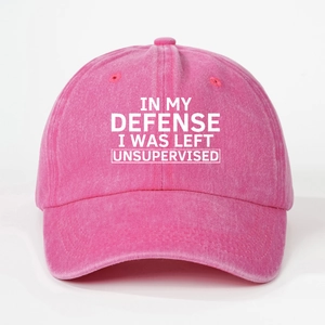Close-up of pink washed cotton baseball cap with white printed text slogan and eyelets
