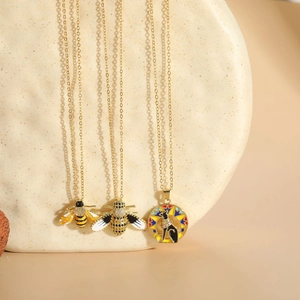 Detailed view of 14K gold plated bee pendants with enamel inlay and sparkling crystals