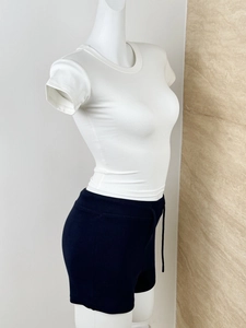 Detail of white modal sports t-shirt and navy drawstring shorts with fine ribbed texture