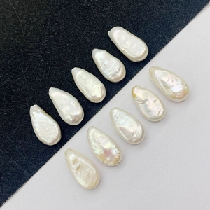 Macro shot of natural baroque freshwater pearls with white iridescent luster on black and white background