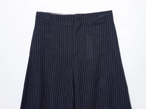 Detailed flat lay of navy blue striped linen trousers with a clean waistline and smooth texture